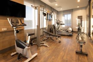 a gym with several exercise bikes and a flat screen tv at Holiday Inn - Eindhoven Airport, an IHG Hotel in Eindhoven