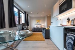 cocina y sala de estar con mesa de cristal en Apartment Nine Staines Upon Thames - Free Parking - Heathrow - Thorpe Park, en Staines