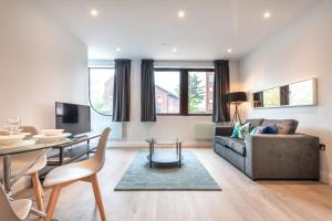 een woonkamer met een bank en een tafel bij Apartment Six Staines Upon Thames - Free Parking - Heathrow - Thorpe Park in Staines