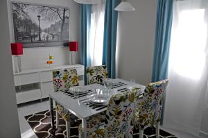 a dining room with a white table and chairs at RSI Apartamentos in Mérida