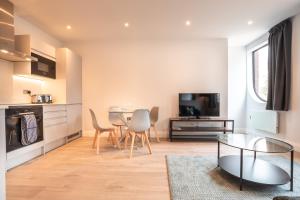 een keuken en een woonkamer met een tafel en stoelen bij Apartment Six Staines Upon Thames - Free Parking - Heathrow - Thorpe Park in Staines