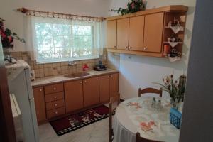 uma cozinha com uma mesa, um lavatório e uma janela em Eretria vacation house em Erétria