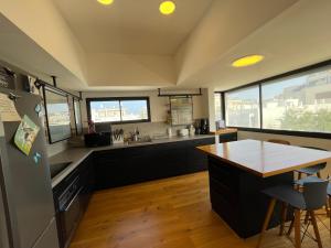 eine Küche mit schwarzen Schränken und einem Holztisch in der Unterkunft Bograshov Rooftop Apartment in Tel Aviv