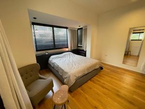 ein Schlafzimmer mit einem Bett, einem Stuhl und einem Fenster in der Unterkunft Bograshov Rooftop Apartment in Tel Aviv