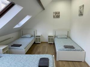 een kamer met 2 bedden op een zolder bij St Thomas House in Antwerpen