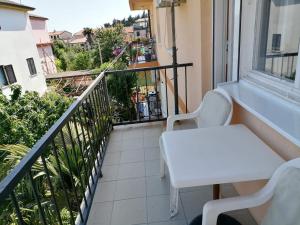 a balcony with a white table and chairs on a balcony at Bolf in Novigrad Istria