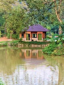 uma pequena casa ao lado de um corpo de água em Katiliya Park Villa em Mae Chan