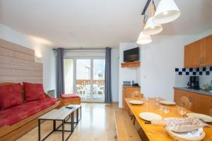 un salon avec un canapé rouge et une table dans l'établissement Balnearia - Appt avec piscine partagée, à Montauban-de-Luchon