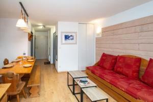 un salon avec un canapé rouge et une table dans l'établissement Balnearia - Appt avec piscine partagée, à Montauban-de-Luchon