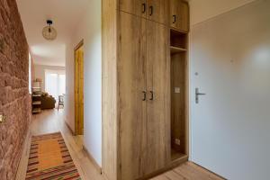 un corridoio con un grande mobile in legno in una stanza di Le Noyer - Appt avec terrasse et jardin partagé a Puberg