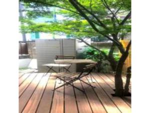 una mesa y sillas en una terraza con un árbol en 3-25-2 Higashiogu - Apartment / Vacation STAY 8340, en Tokio