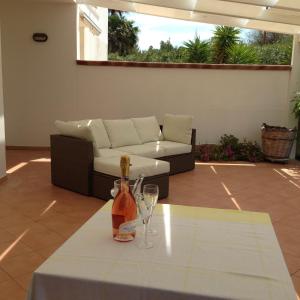 una mesa con dos copas de vino y un sofá en villa Annarè, en Torre dell'Orso