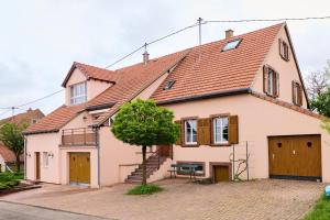 een wit huis met een rood dak bij Le Pommier - Appt avec jardin partagé in Puberg