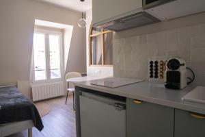 eine Küche mit einer Spüle und einer Arbeitsplatte in der Unterkunft Bright 20m near the Eiffel Tower in Paris