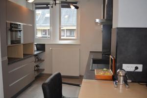 a kitchen with a counter and a table with a chair at Appartement-terrasse parking privé Meublé de Tourisme 4 étoiles in Belfort