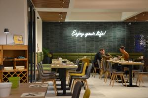 two men sitting at tables in a restaurant at Elite Hotel & Spa in Mestre