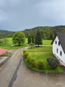 an empty road with a white house and a field at Ferienwohnung Antonie in Tettnang
