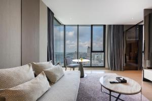 a living room with a couch and a large window at Grand Richmond Stylish Convention Hotel in Nonthaburi