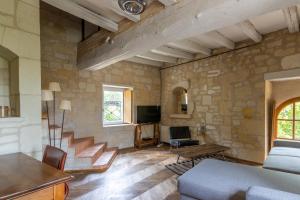 sala de estar con escaleras y pared de piedra en Gîte Divin - Belle maison champêtre, en Doué-la-Fontaine