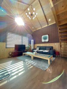 a living room with a couch and a table at Sodamhyang Pension in Jeju