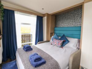 a bedroom with a bed with blue towels on it at Balvicar Beag in Oban