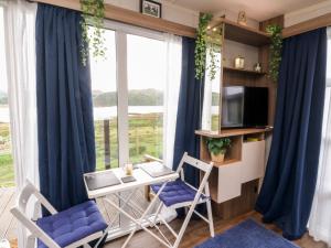 a living room with a table and chairs and a window at Balvicar Beag in Oban