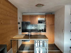 a kitchen with wooden cabinets and a counter top at Duplex 10 personnes in Saint-Lary-Soulan