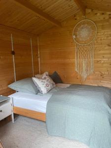 uma cama num quarto com uma parede de madeira em Gartenhäuschen im Grünen em Bad Aibling