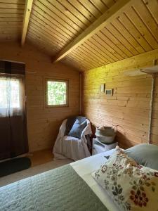 um quarto com uma cama num chalé de madeira em Gartenhäuschen im Grünen em Bad Aibling