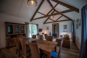a living room with a wooden table and chairs at Florie Cottage in Cserszegtomaj
