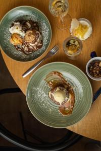 dos platos de comida en una mesa de madera en Kyriad Nuits-Saint-Georges en Nuits-Saint-Georges