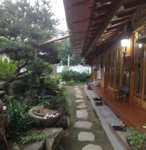 a garden outside of a building with a walkway at Beautiful Garden Fine Day House in Jeonju