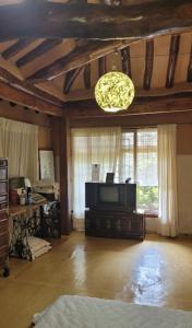 uma ampla sala de estar com uma televisão e um lustre em Beautiful Garden Fine Day House em Jeonju