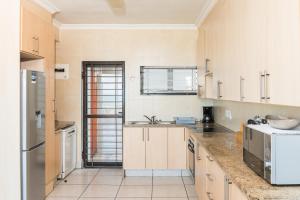 a large kitchen with a sink and a refrigerator at Boulder Bay 9 in Ballito