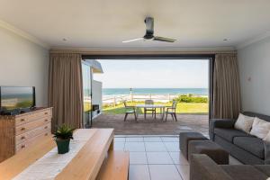 a living room with a couch and a television and a table at Boulder Bay 9 in Ballito