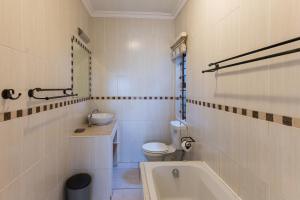 a bathroom with a toilet and a sink and a tub at Boulder Bay 9 in Ballito +2 photos