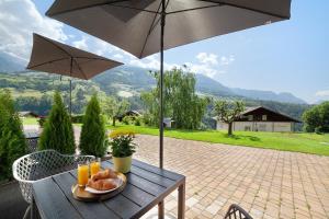 uma mesa com um prato de comida e um guarda-chuva em Alivo Living Apartment Olivia em Rifiano