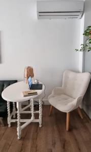 a white table and a chair with a laptop on it at Unique Sea & City Lifestyle Studio in Limassol