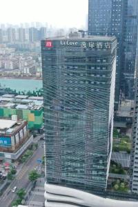 um edifício alto com um cartaz numa cidade em UrCove by HYATT Shenzhen Luohu em Shenzhen