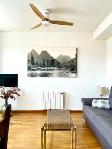 a living room with a couch and a ceiling fan at La Casa de Mansilla in Mansilla de las Mulas +10 photos
