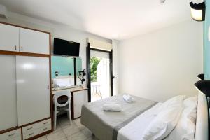 a bedroom with a bed and a desk with a mirror at Hotel Criniera D'oro in Rimini