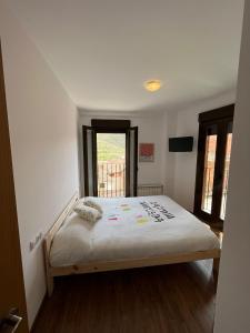 a bedroom with a bed in a room with a window at Javalambre Mountain Superski in Camarena de la Sierra