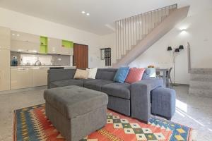 a living room with a couch and a chair and a kitchen at Goethe Dépendance in Agrigento