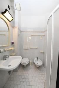 a white bathroom with a sink and a toilet at Hotel Criniera D'oro in Rimini