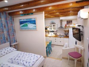 een kleine slaapkamer met een bed en een keuken bij Apartments Sumic Harbour view in Makarska