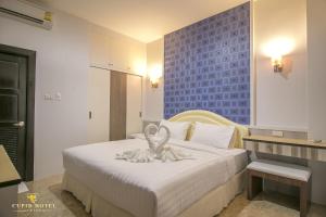 a bedroom with a white bed with a statue on it at Cupid Hotel in Ban Thung Yao +41 photos