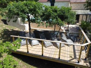 una terraza elevada con sillas y árboles en un patio en Magnifique Villa de prestige, piscine chauffée en Marnac