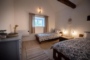 a bedroom with two beds and a window at Florie Cottage in Cserszegtomaj