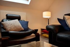 a living room with a chair and a couch at Appartement-terrasse parking privé Meublé de Tourisme 4 étoiles in Belfort