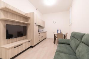 a living room with a couch and a flat screen tv at Palazzetto La Quadra di San Faustino - F&L Apartment in Brescia